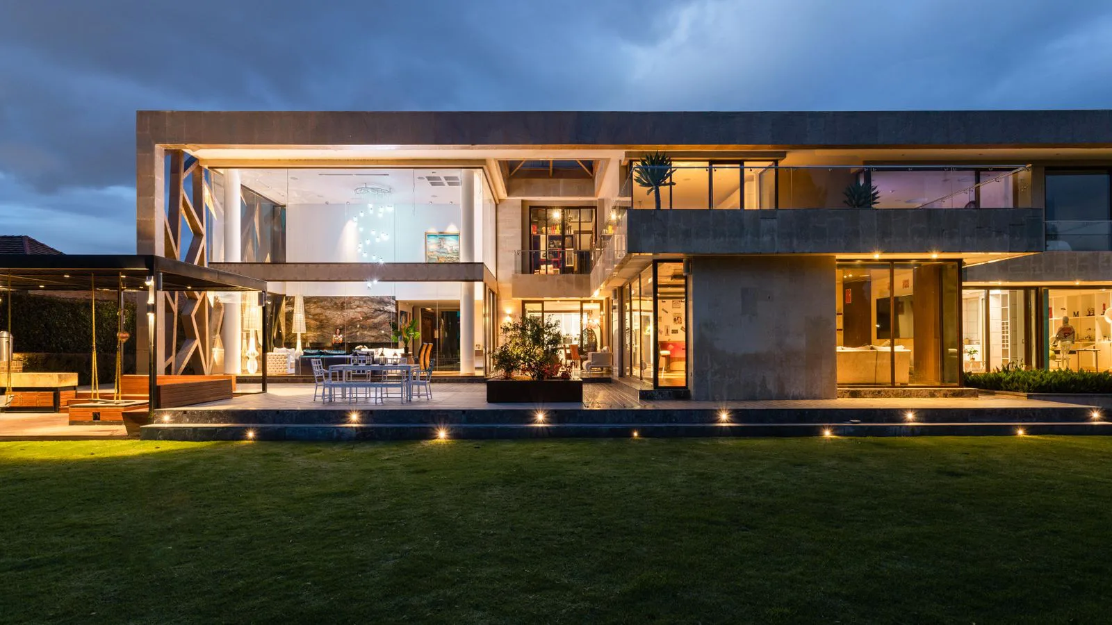 Una casa contemporánea iluminada desde dentro al anochecer.