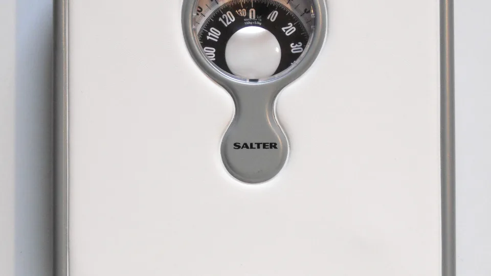 The dial of a mechanical bathroom scale, seen close up.