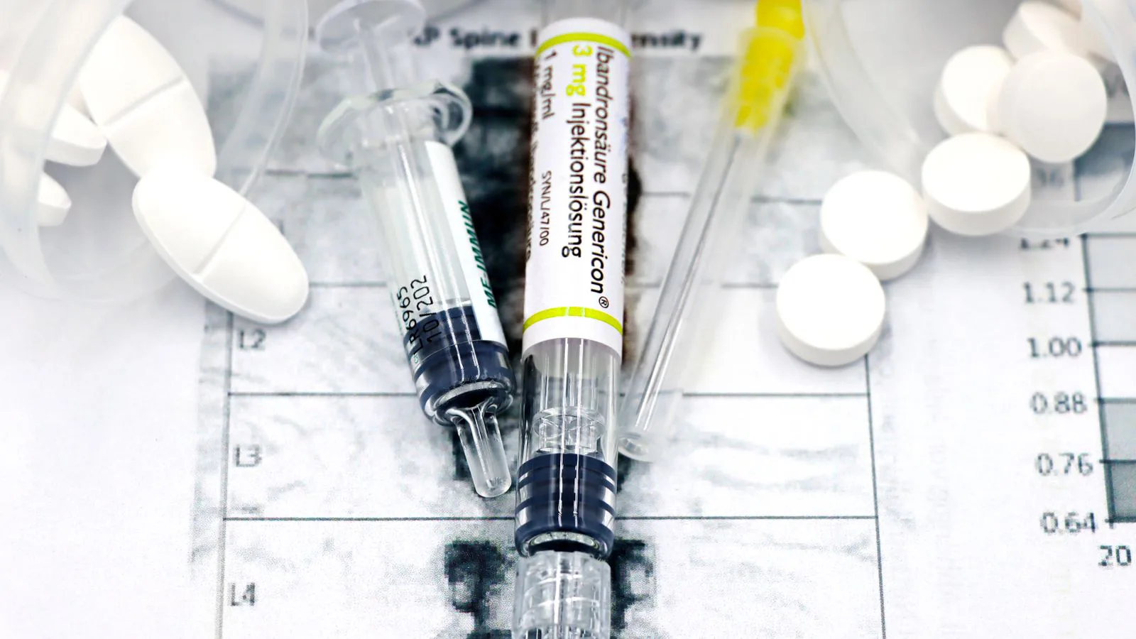Des seringues et des comprimés posés sur une feuille de résultats de laboratoire.