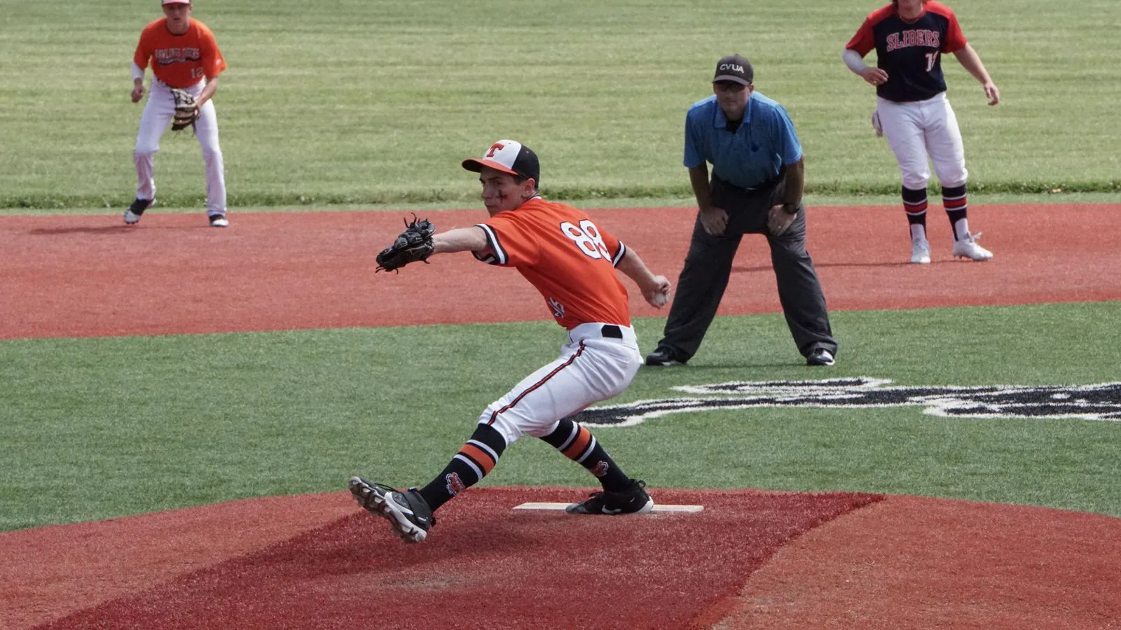 Un lanciatore di baseball in pieno lancio durante una partita.