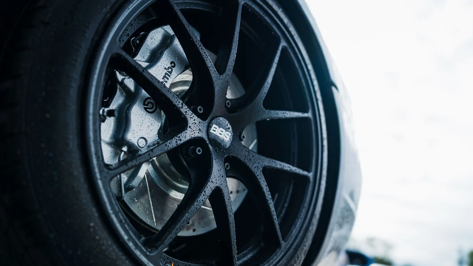 A car wheel and tyre, close up, brake disc visible behind the spokes.