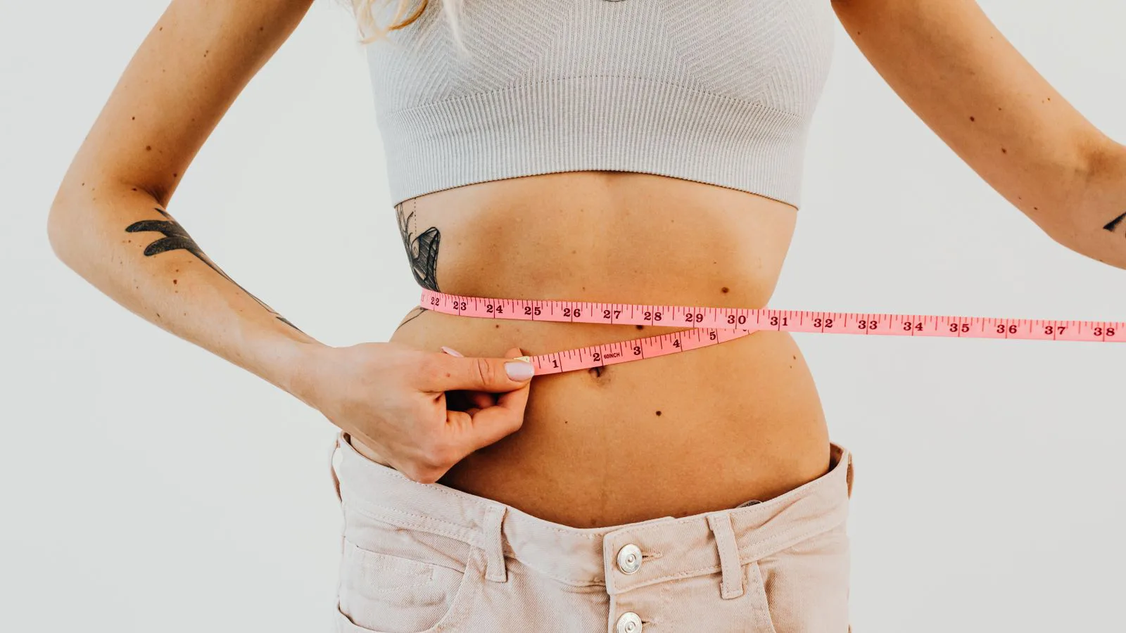 A tape measure being drawn around a waist.