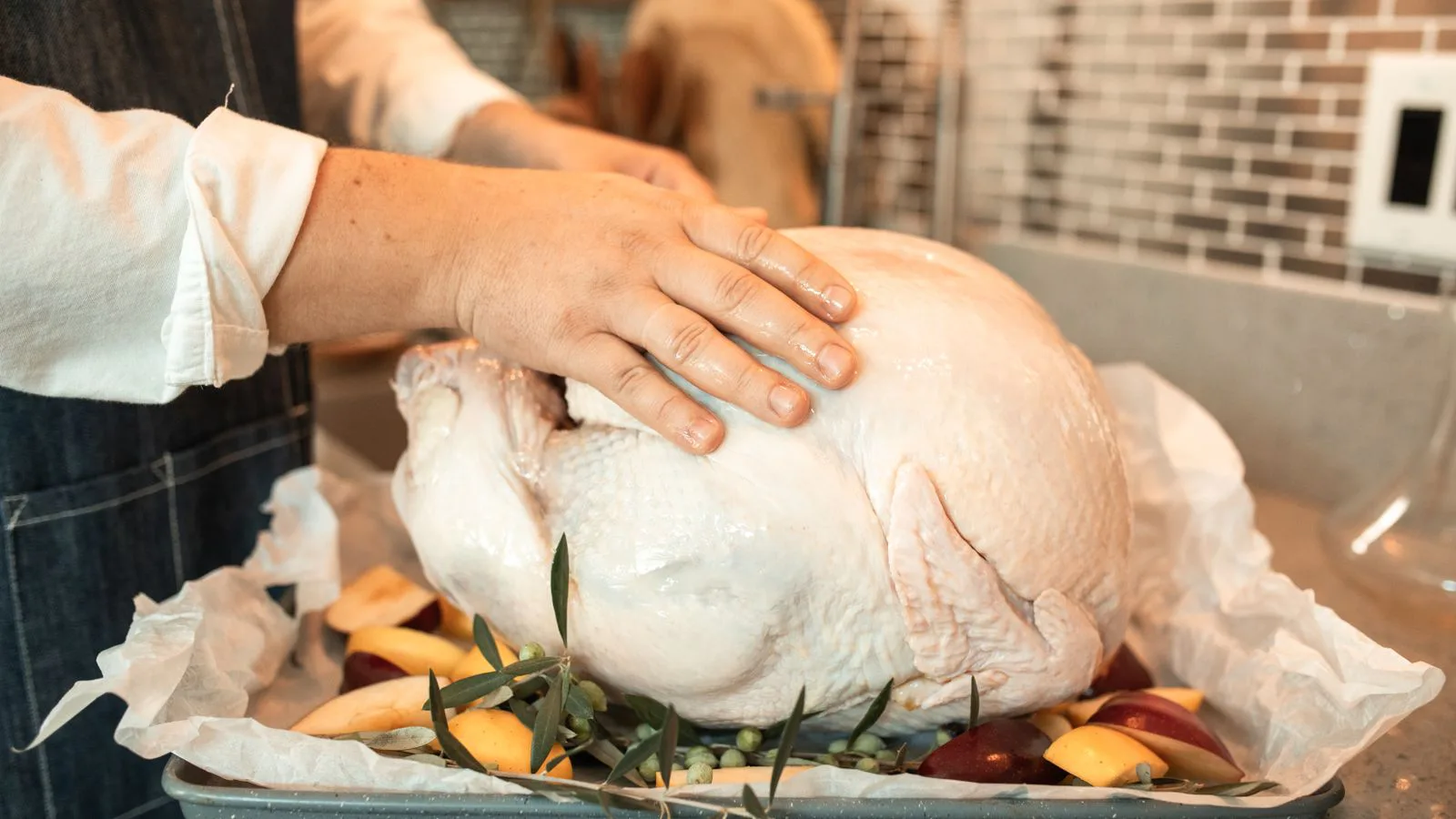 A raw turkey on a tray, ready to be prepared.