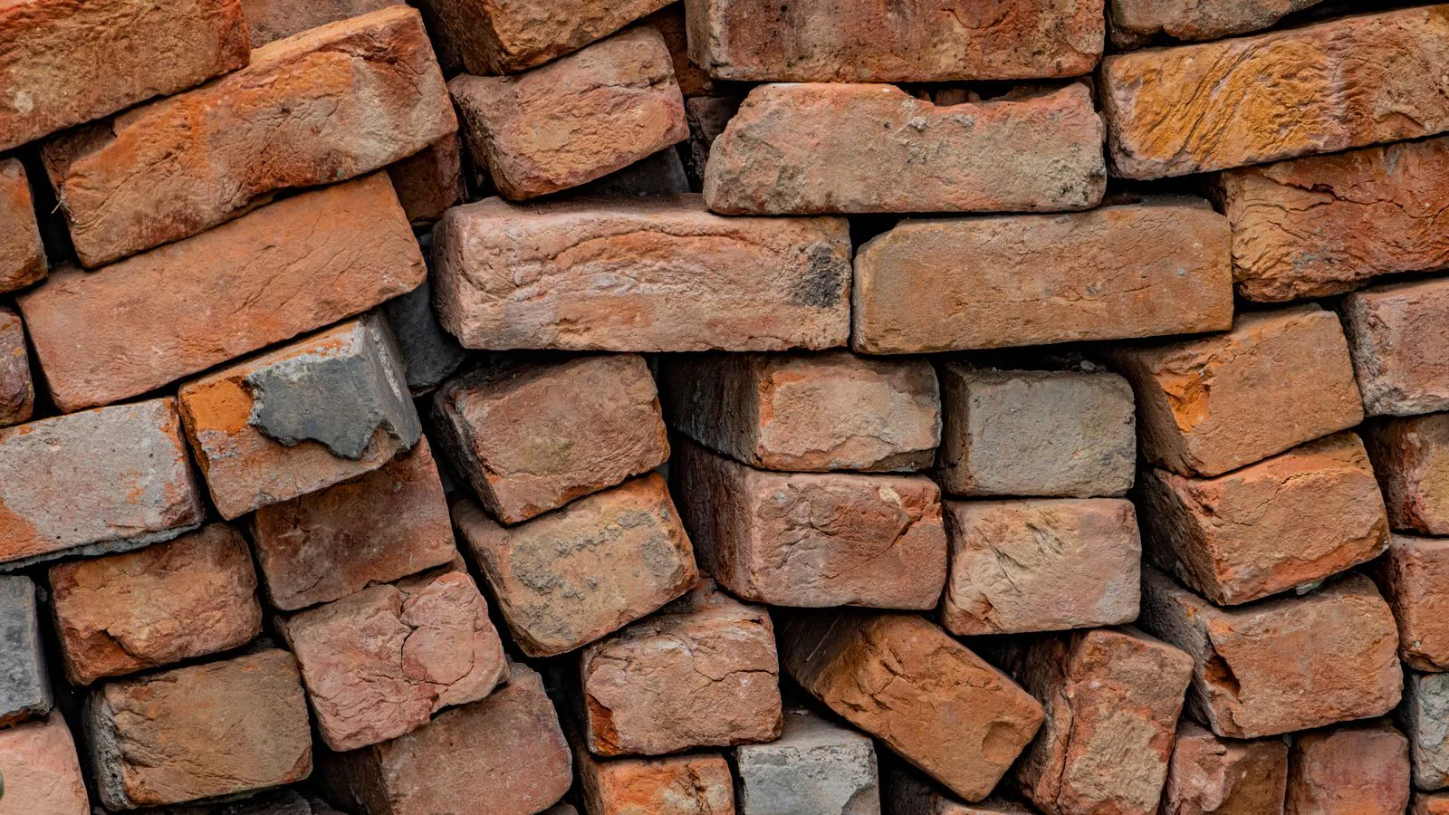 A stack of bricks, close up, with their colour and texture varying.