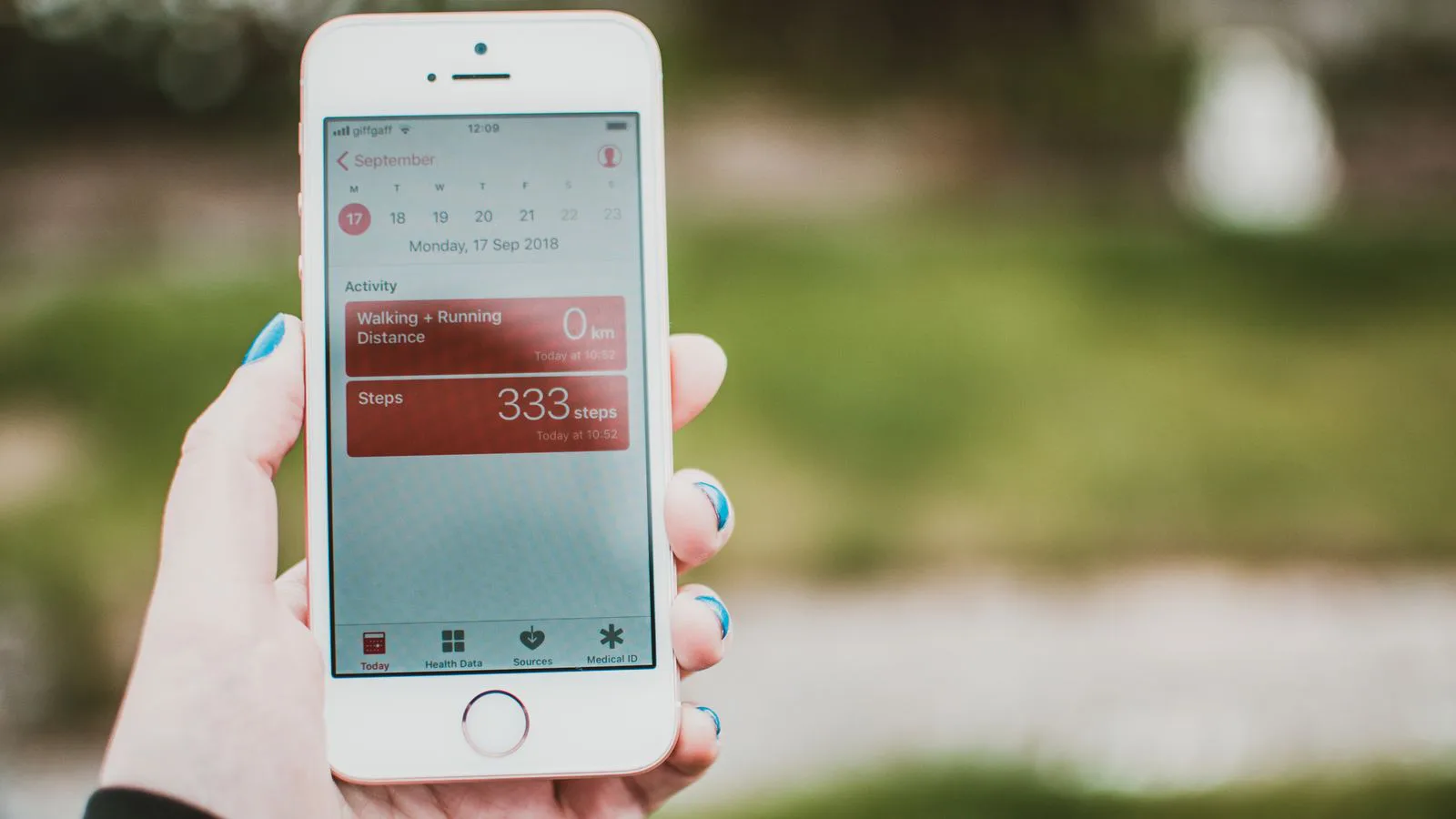 A phone showing a fitness app with the day's step and calorie count.
