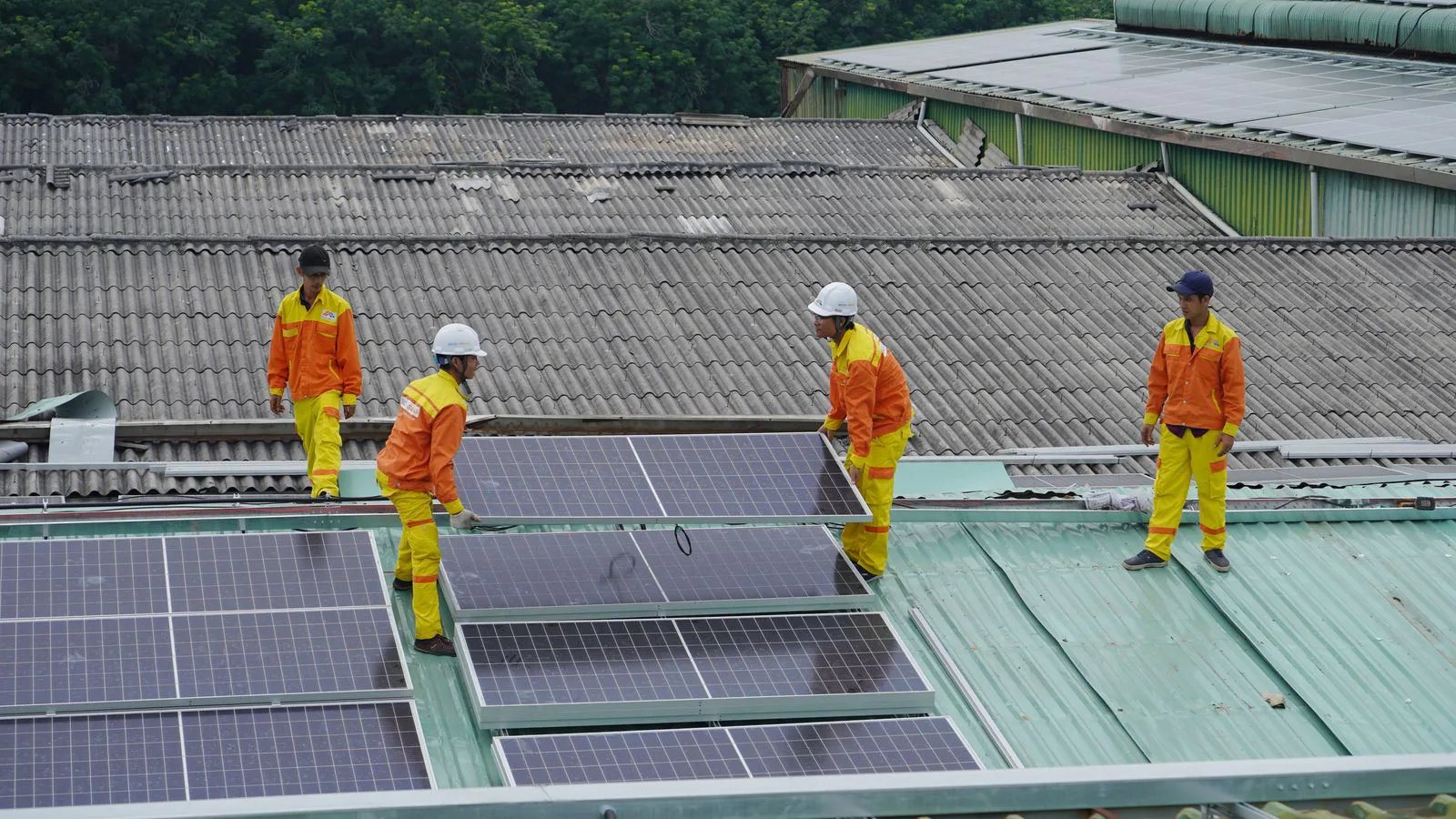 Arbeiter montieren Solarmodule auf einem Dach.