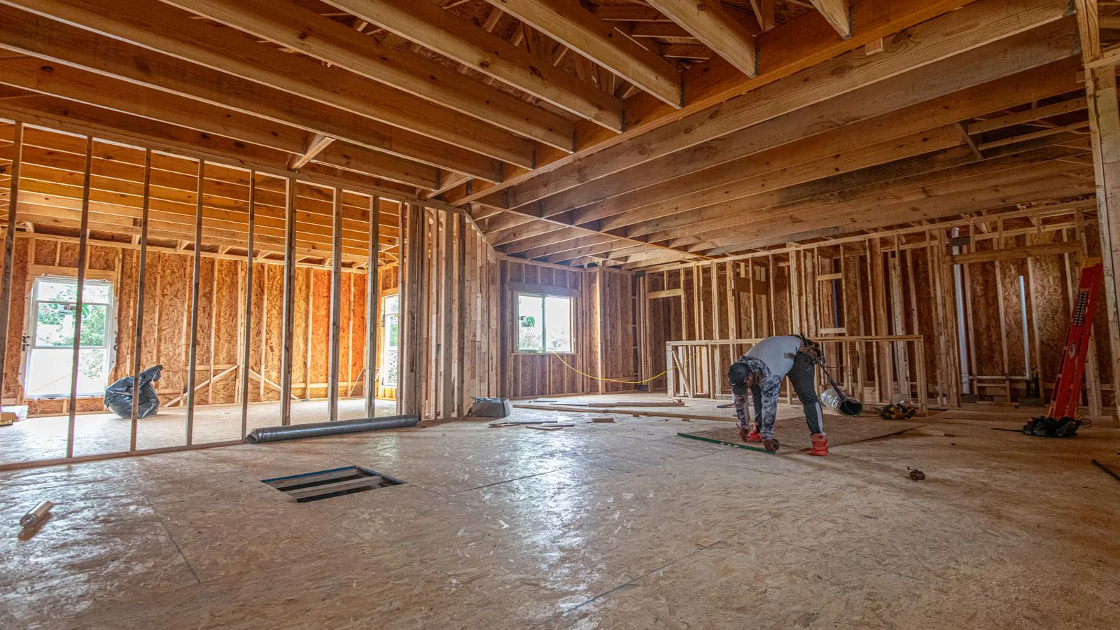 The inside of a house under construction, timber stud walls exposed.