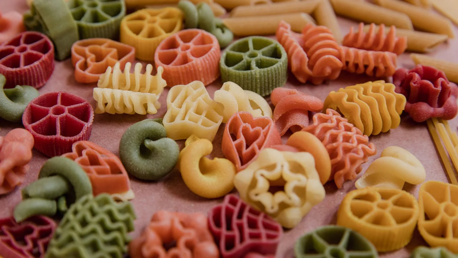 Dried pasta in assorted shapes and colours, close up.
