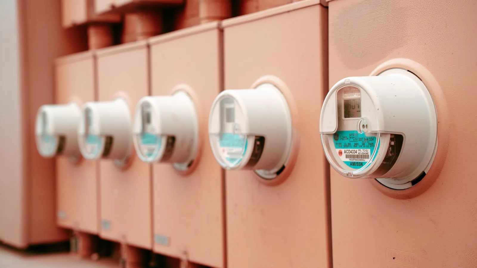 A row of electricity meters mounted side by side.