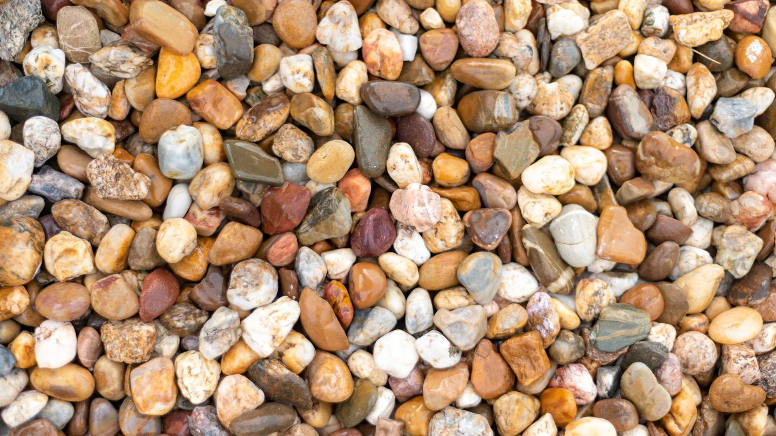 Rounded pebbles of mixed colour, filling the frame.