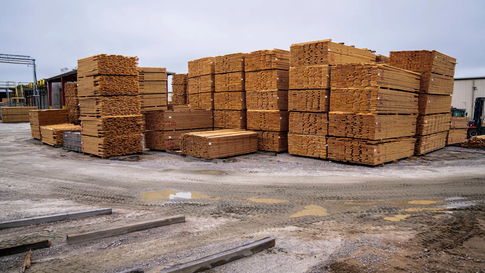 Stapel gesägter Bretter auf einem Holzlagerplatz im Freien.