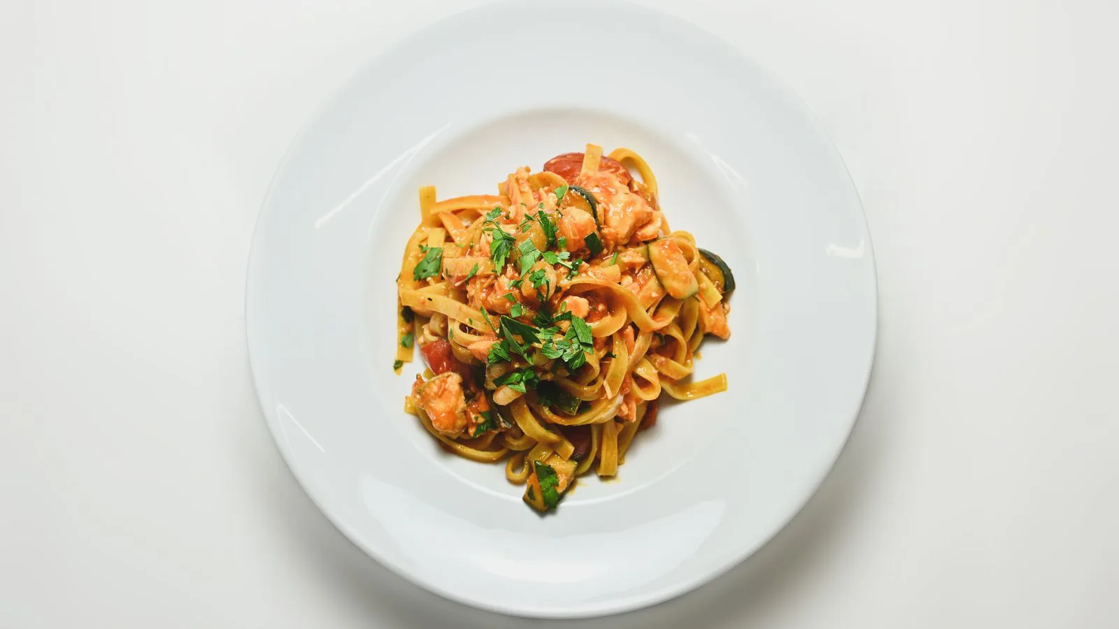 A single portion of pasta plated with herbs, seen from above.
