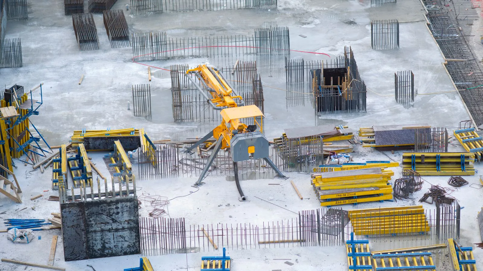 Aerial view of a construction site with machinery and stacked materials.