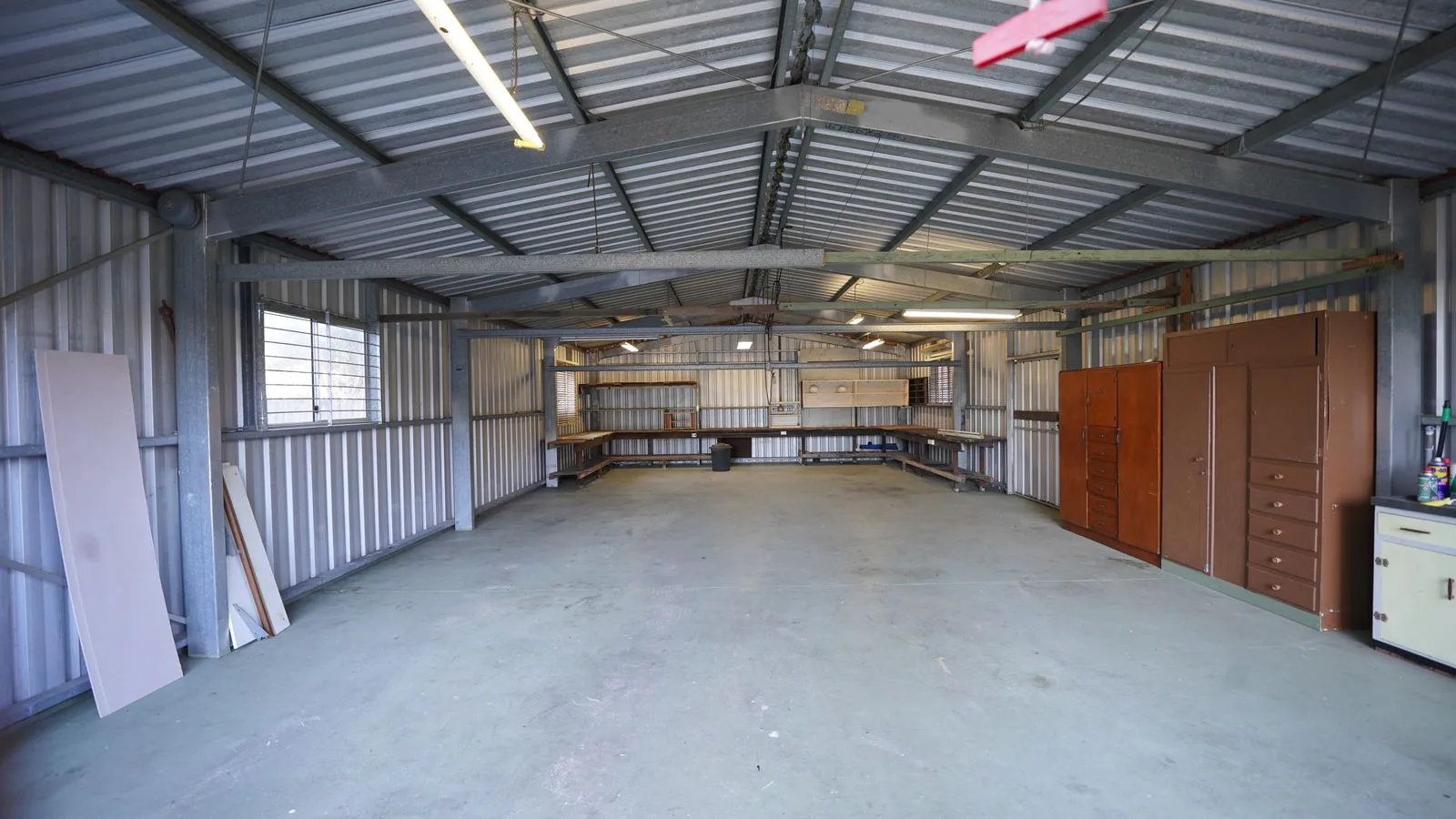 An empty garage with metal walls and a concrete floor.