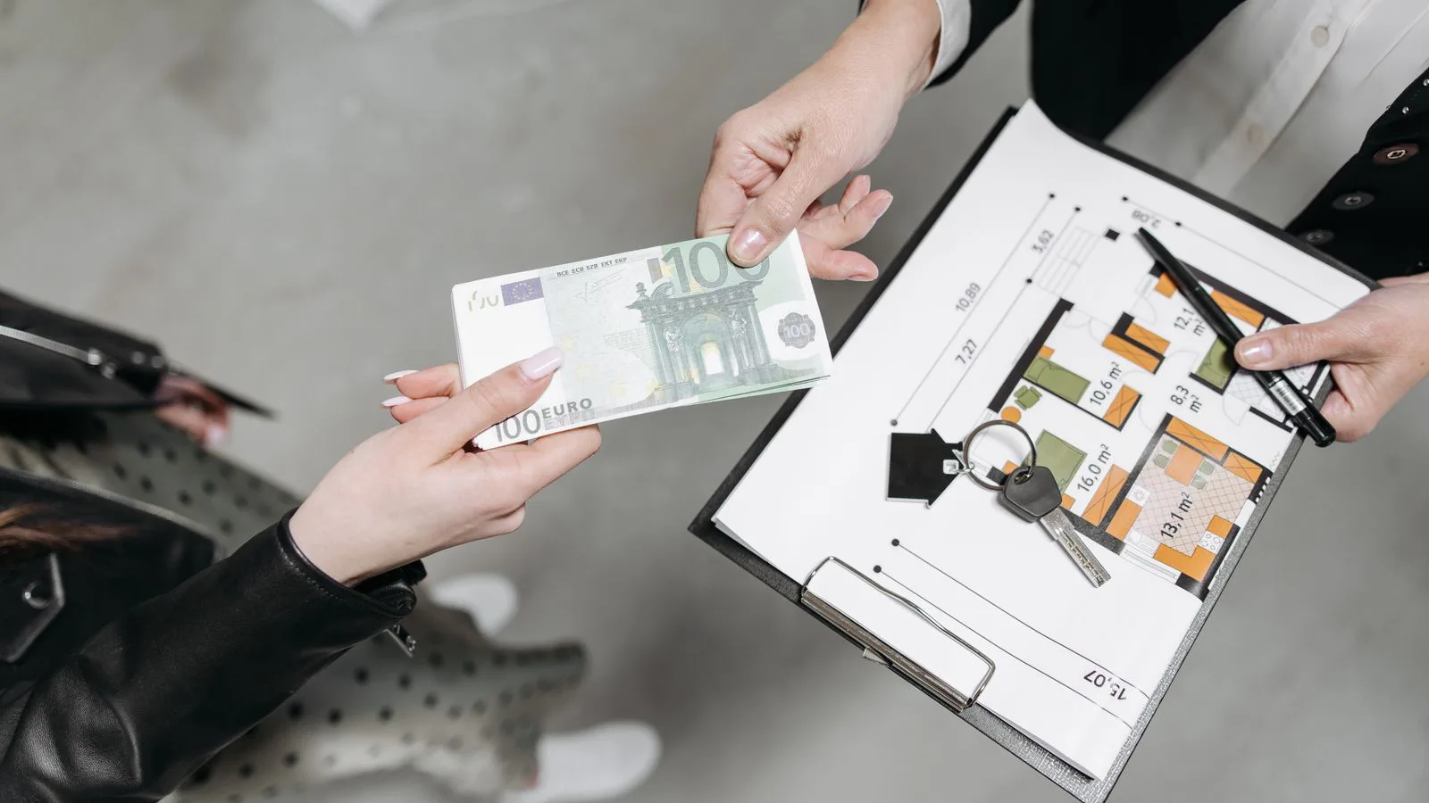 A euro note, keys and a floor plan on a table.