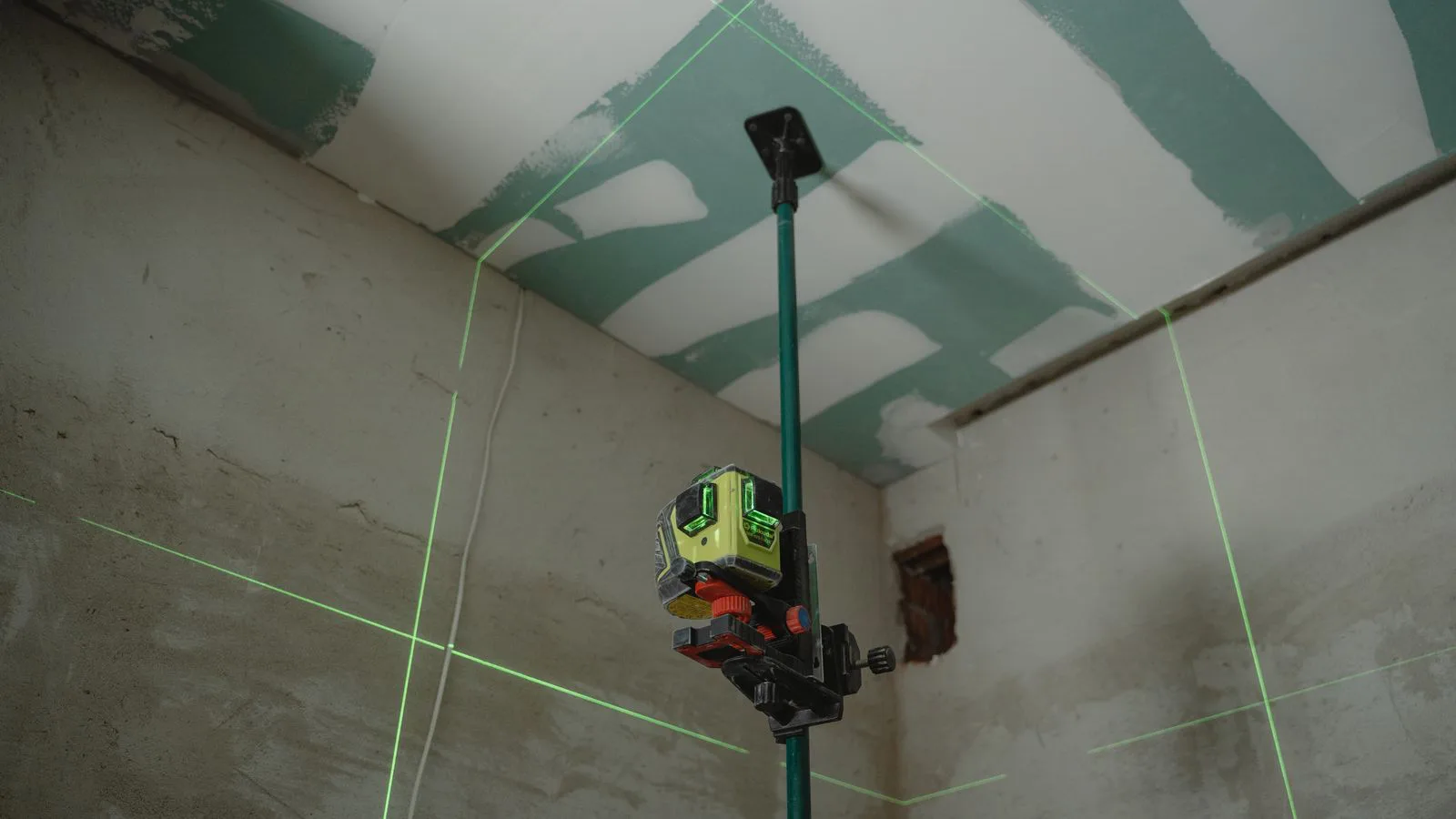 A laser level projecting lines across an empty room.