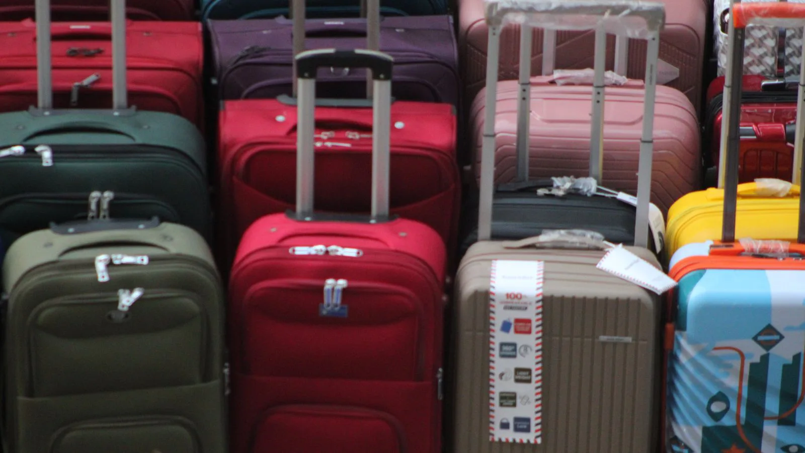 A stack of suitcases of different sizes and colours.