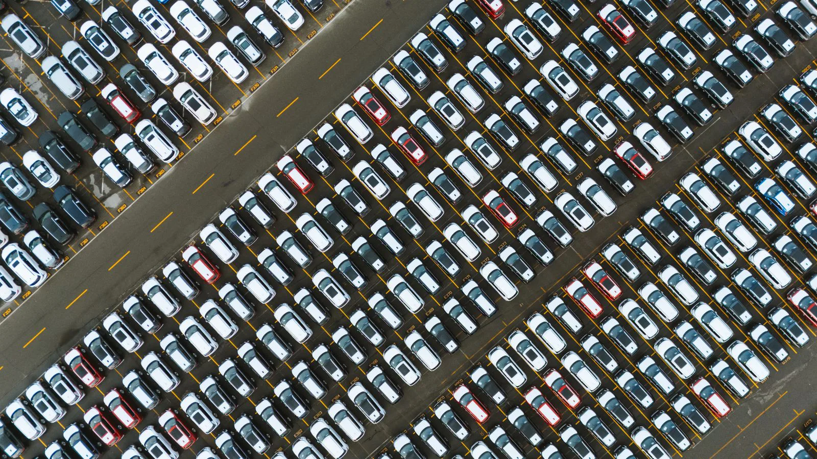 Cars parked in neat diagonal rows, seen from the air.