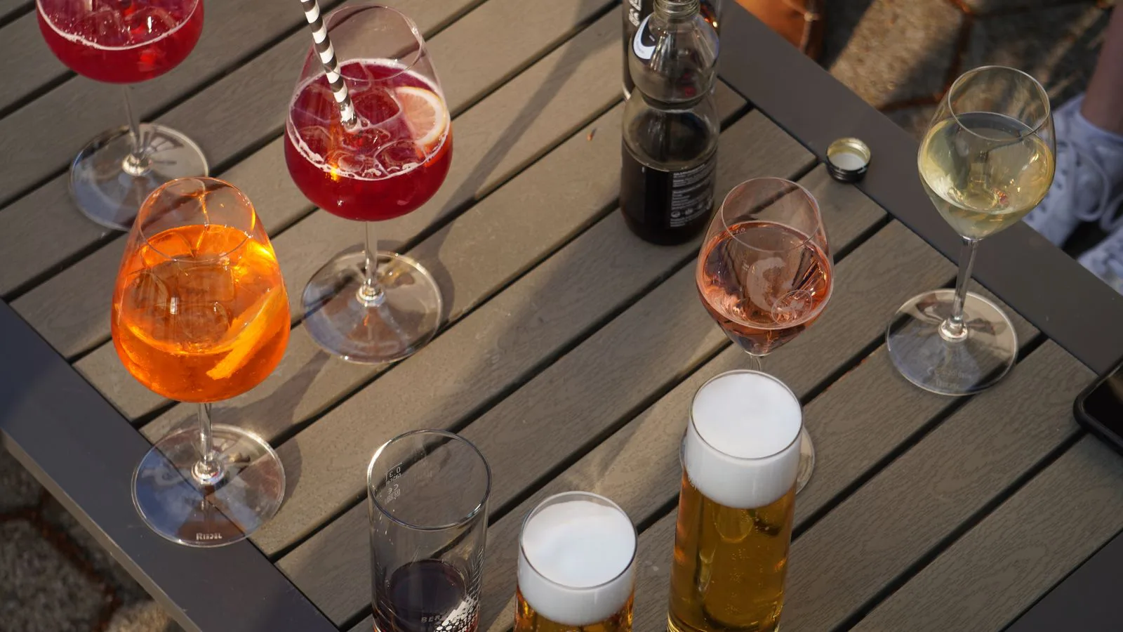 An assortment of cocktails, wine and beer on a table, seen from above.