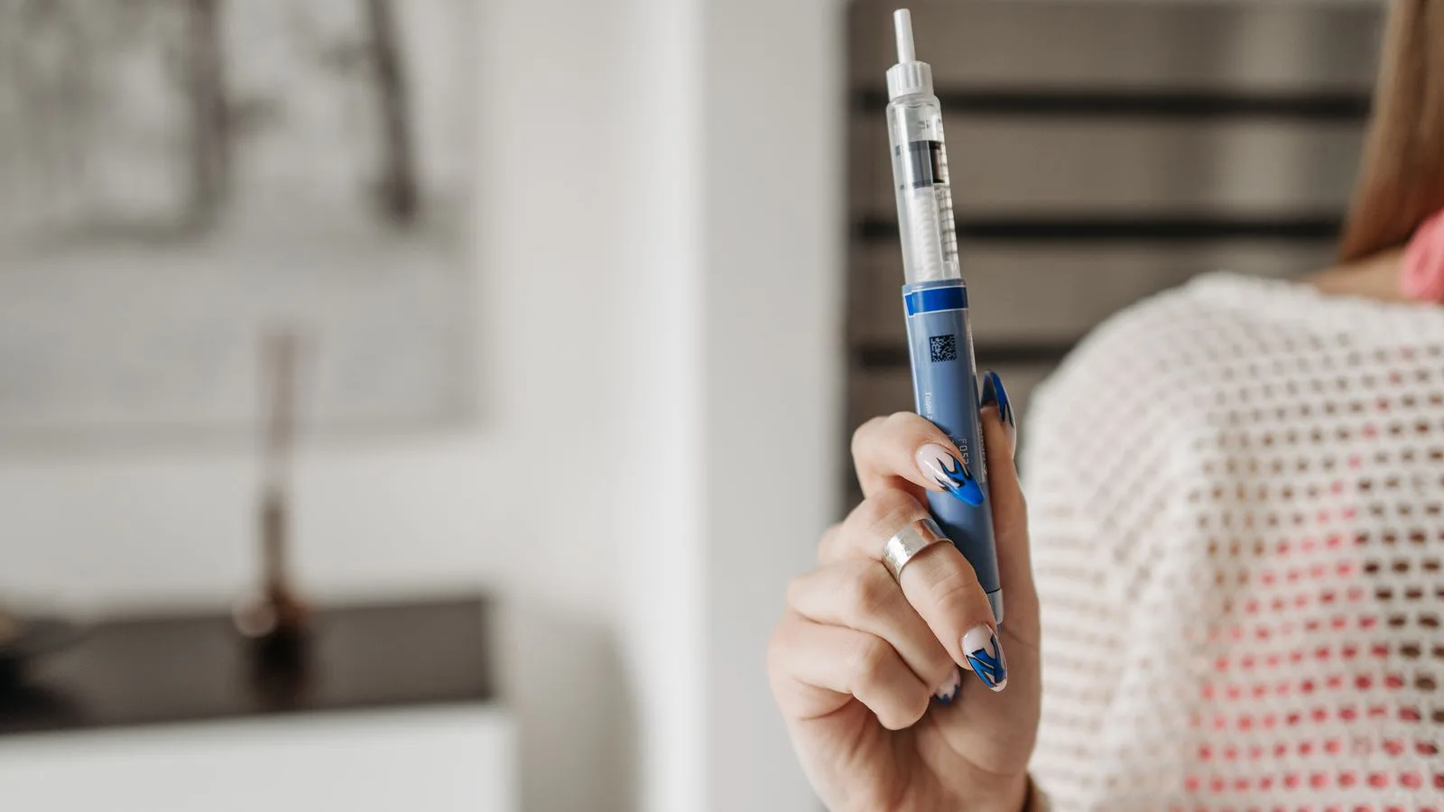 A woman holding an insulin pen.