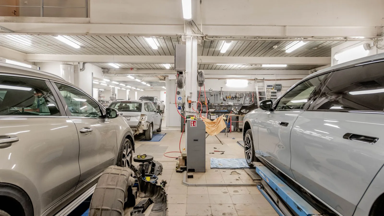 Cars raised on ramps inside a repair workshop.