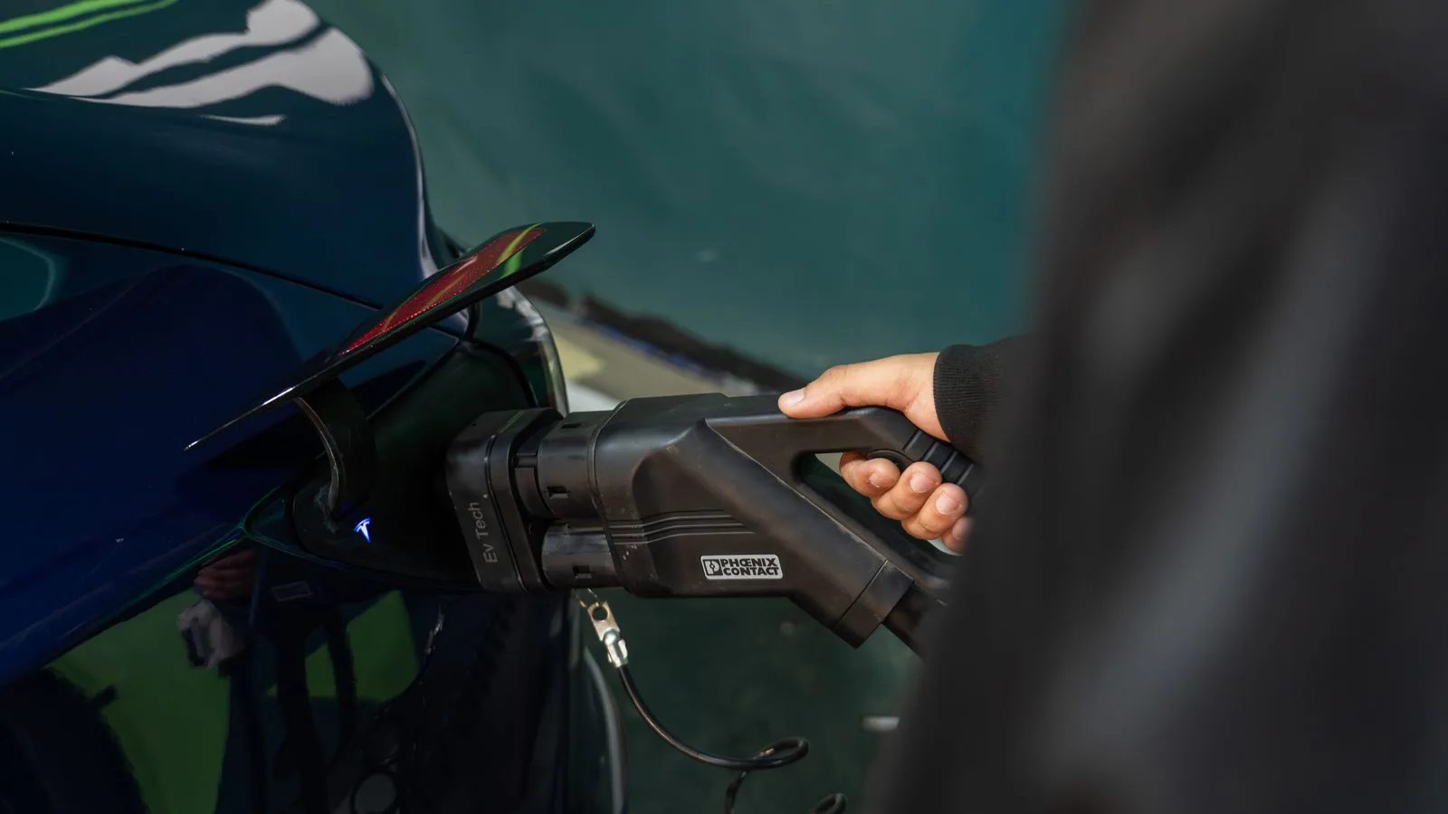 An electric vehicle connected to a charging point, close up.