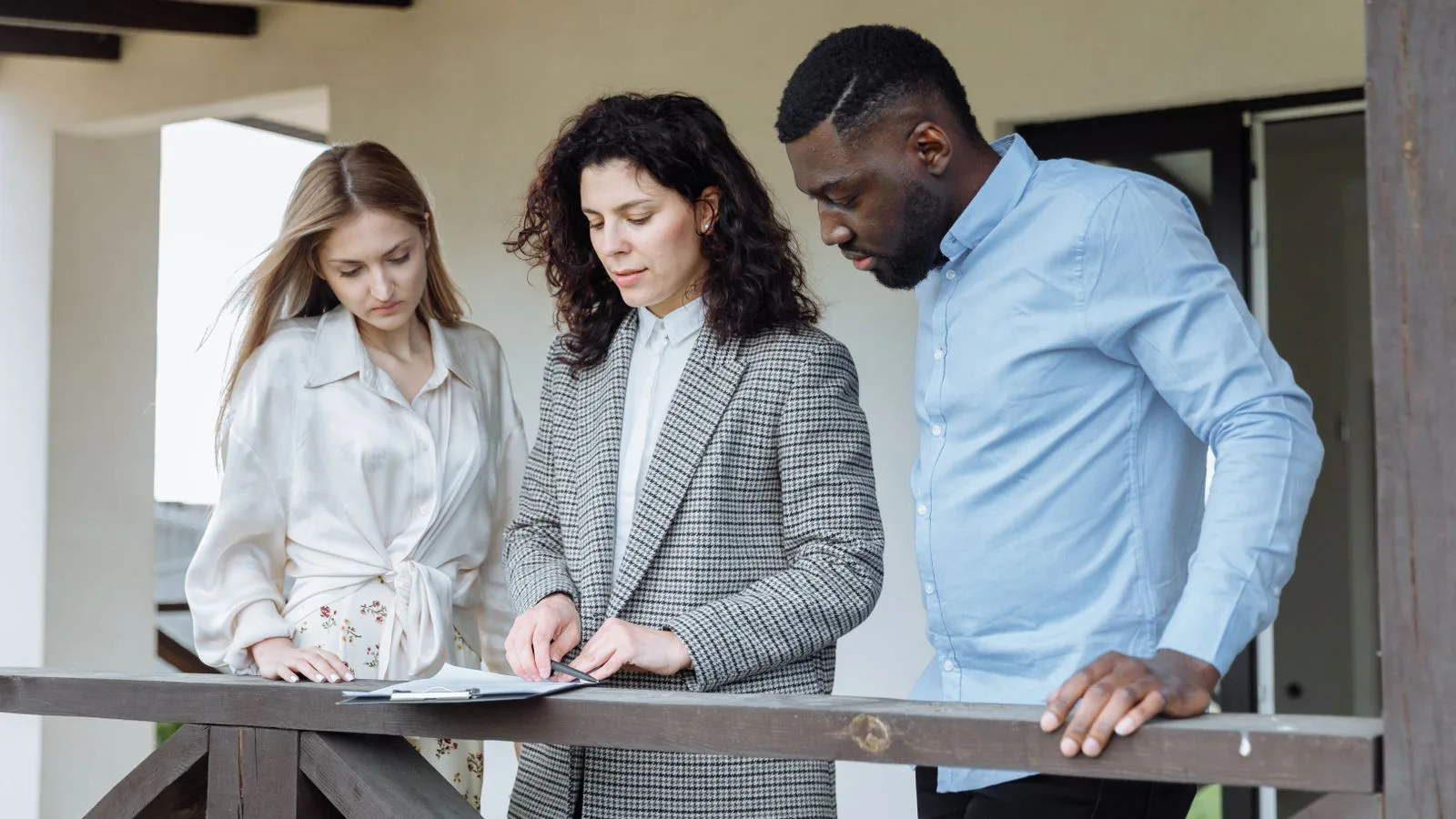 Three people going over documents during a property transaction.