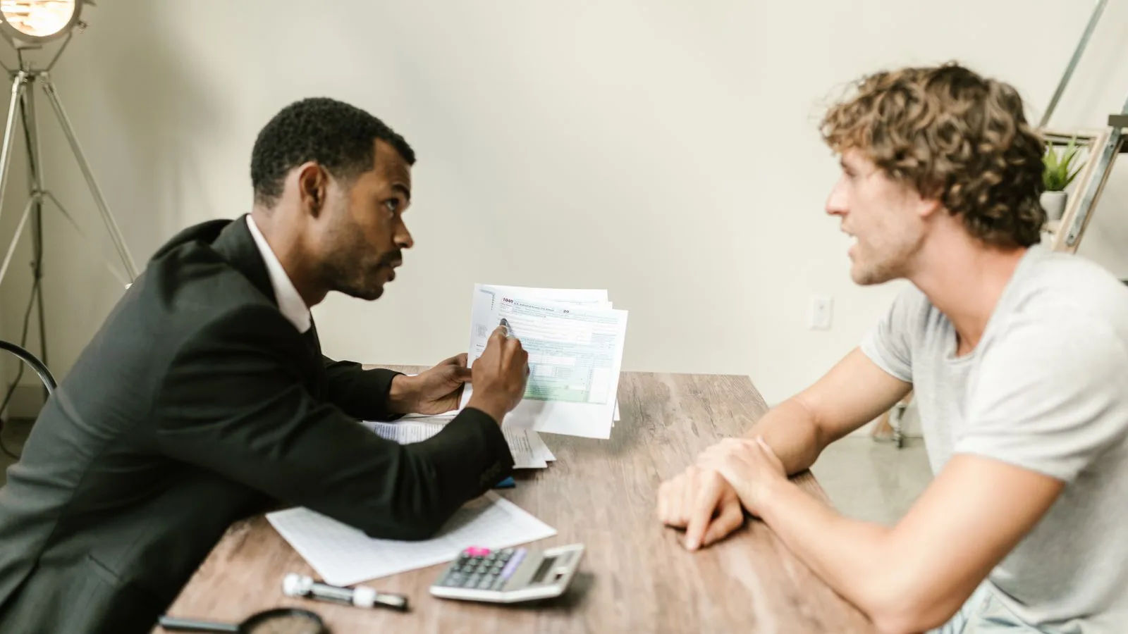 An adviser going through paperwork with a client at a desk.