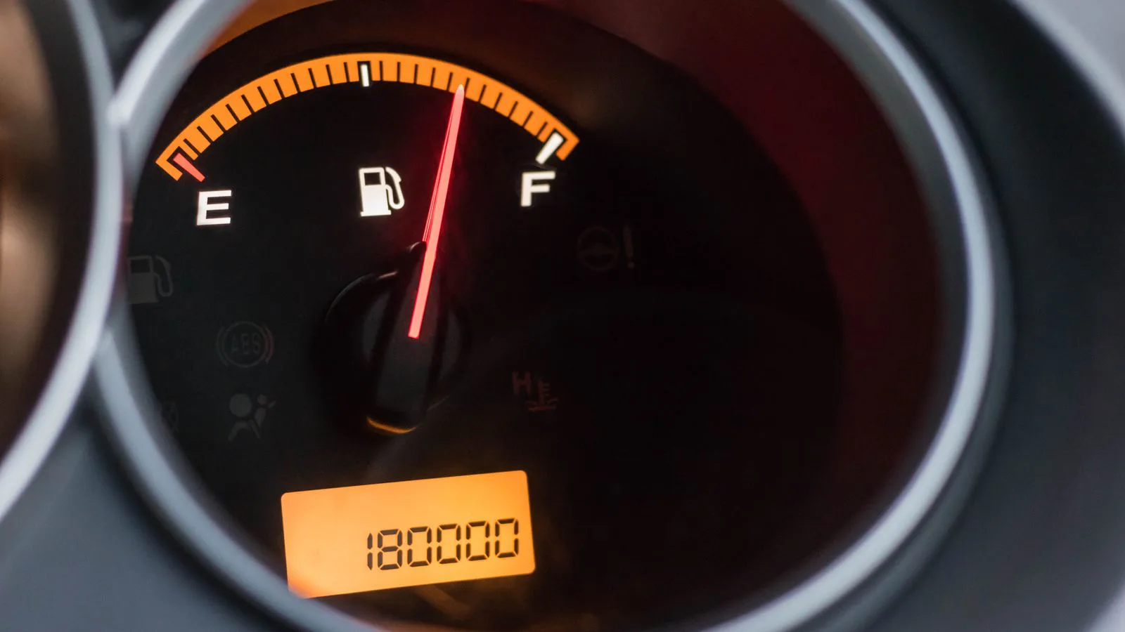 A car's fuel gauge reading full, odometer below.