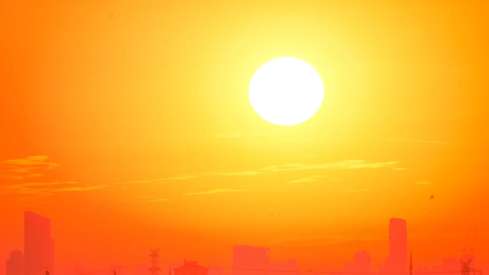 A city skyline against a burning orange sky.