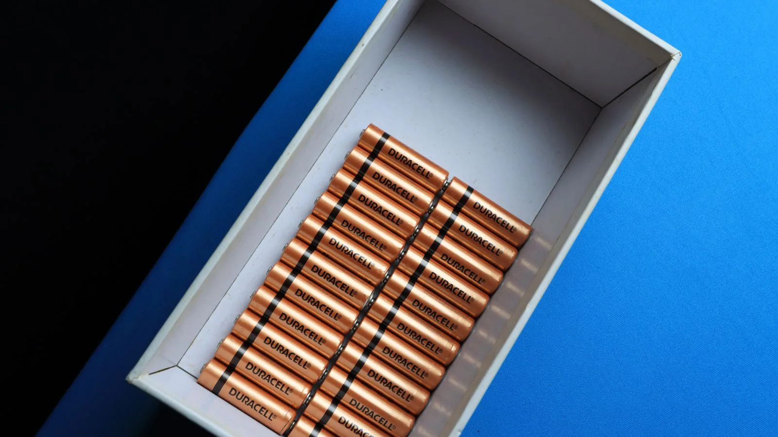 Battery cells arranged in rows inside an open box.