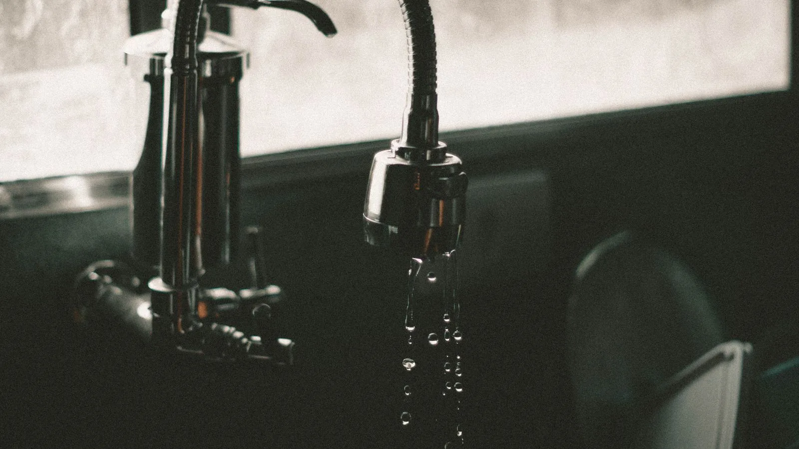 Water running from a kitchen tap into the sink below.